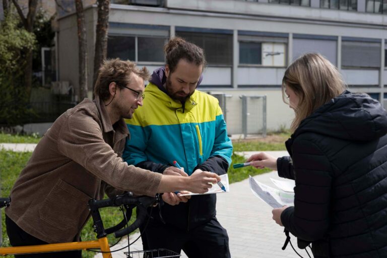 Three people on foot and by bycicle that are mapping their surroundings with the Sketch Map Tool