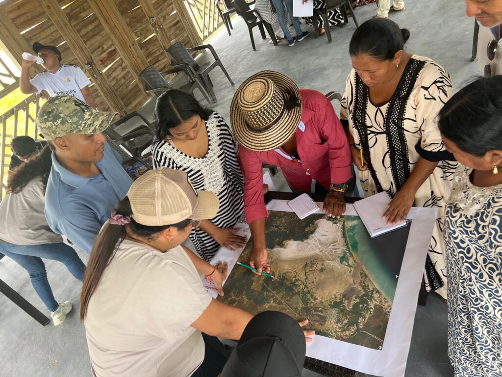 people sitting at a table, discussing over a map