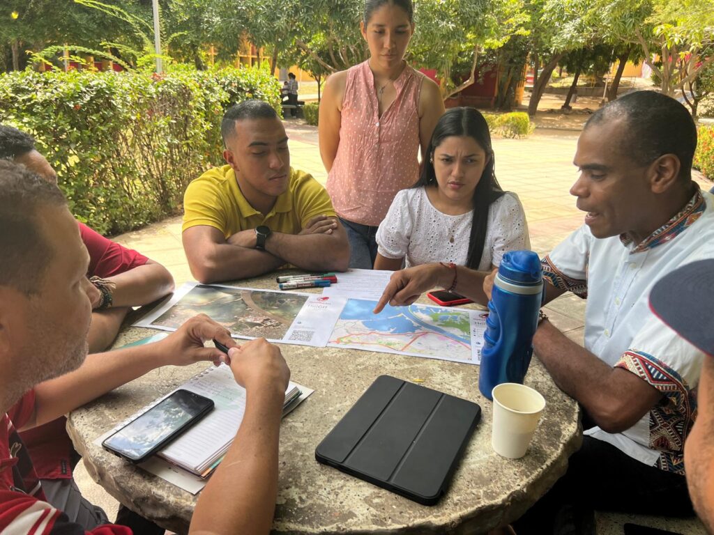 people sitting at a table, discussing over a map