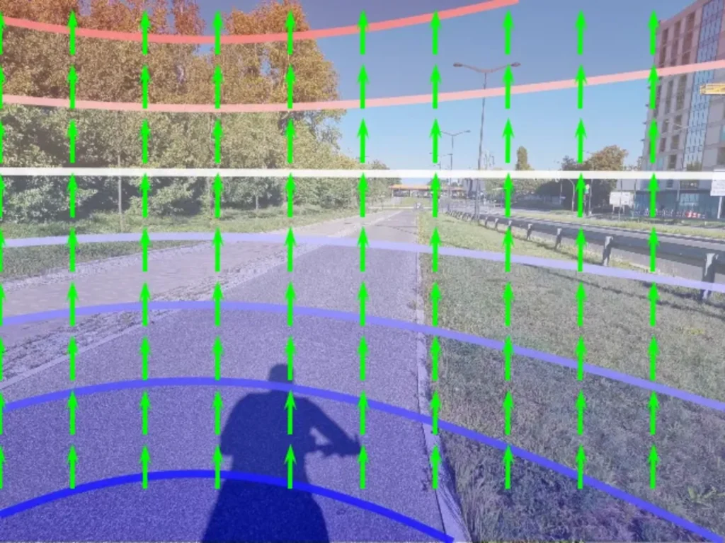 Street with sidewalk and grassy strip overlaid with colored lines and green arrows, foreground shows shadow of person with raised hand to head