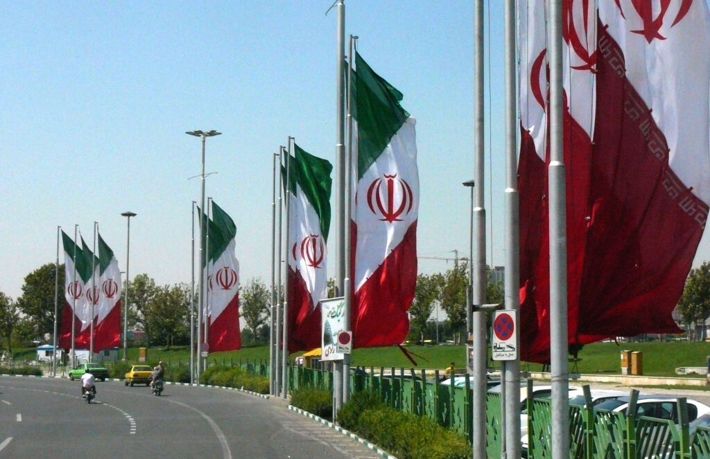The images shows a highway decorated with Iranian flags