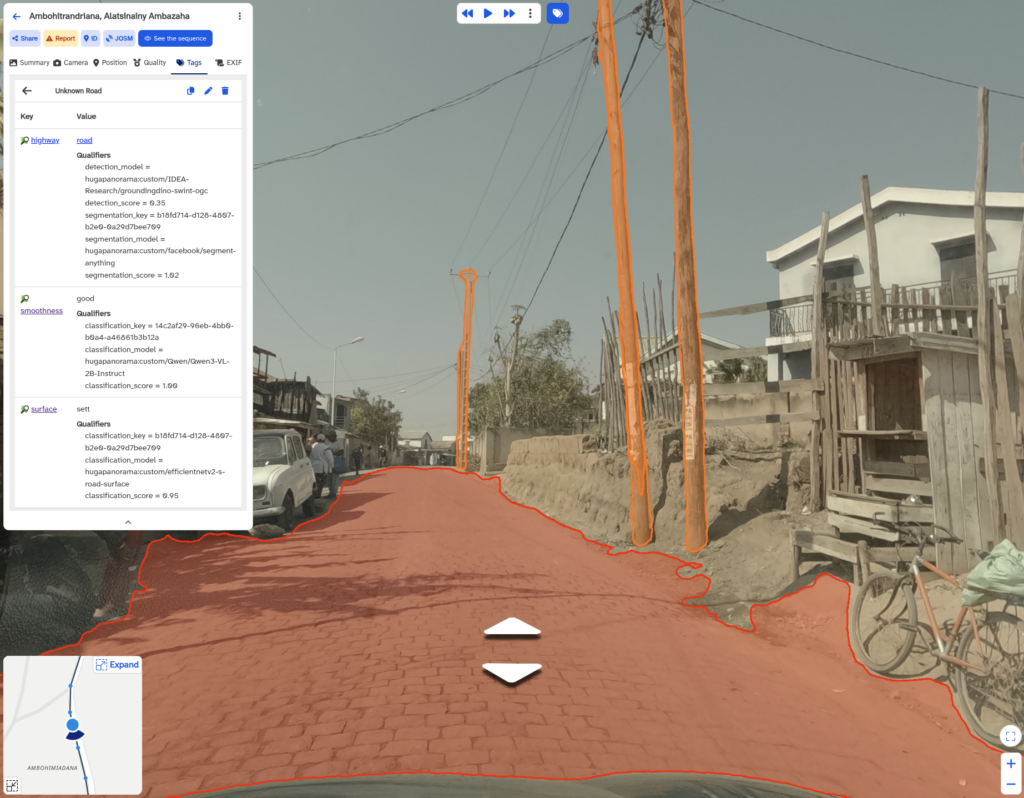 Street view of a paved road with utility poles and wires on the right side and a bicycle leaning against a fence near a white building