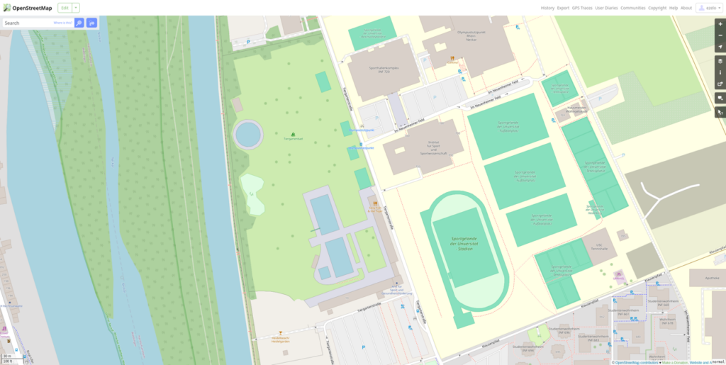 Map section showing a river on the left, green park areas, and a cluster of buildings with labels and pathways on the right